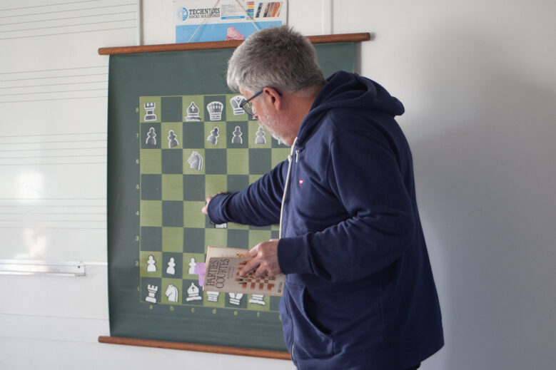 Jean-Marc Seng, le coach, présentant aux enfants une partie miniature.